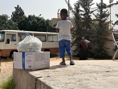Photo: WFP/Yousef Amesh Child next to a box of WFP food.
