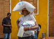 A woman carries WFP food bags in Haiti, which is hit by funding cuts. Photo: WFP/Luc Junor Segur
