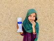 A smiling Afghan primary schoolgirl displays a package of WFP fortified biscuits. Photo: WFP/Sayed Abidullah Sadat