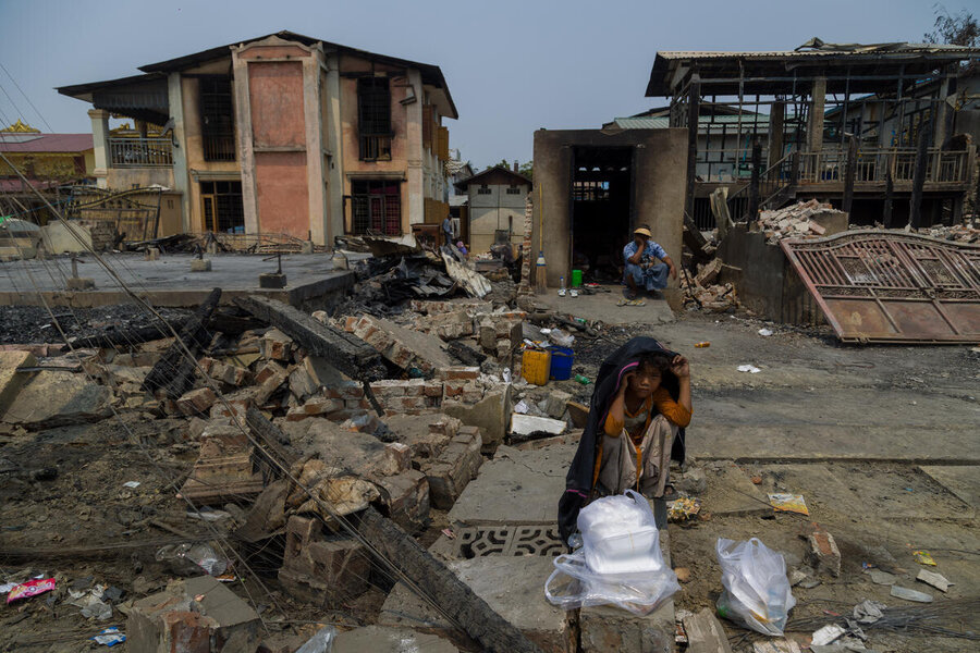 A boy covers his head with a jacket in an earthquake-struck area, apparently fearing aftershocks