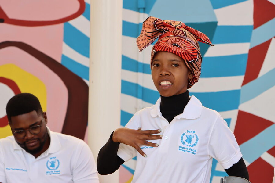 A young female intern with a white WFP shirt in Mozambique looks into the camera 