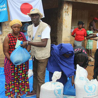 Woman receiving food assistance from WFP staff in Gueckedou, Guinea