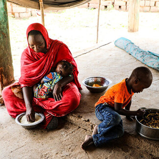 A mom and her two children are eating food together