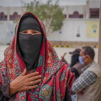 A woman with her hand on her chest. Photo: WFP/Mohammed Awadh